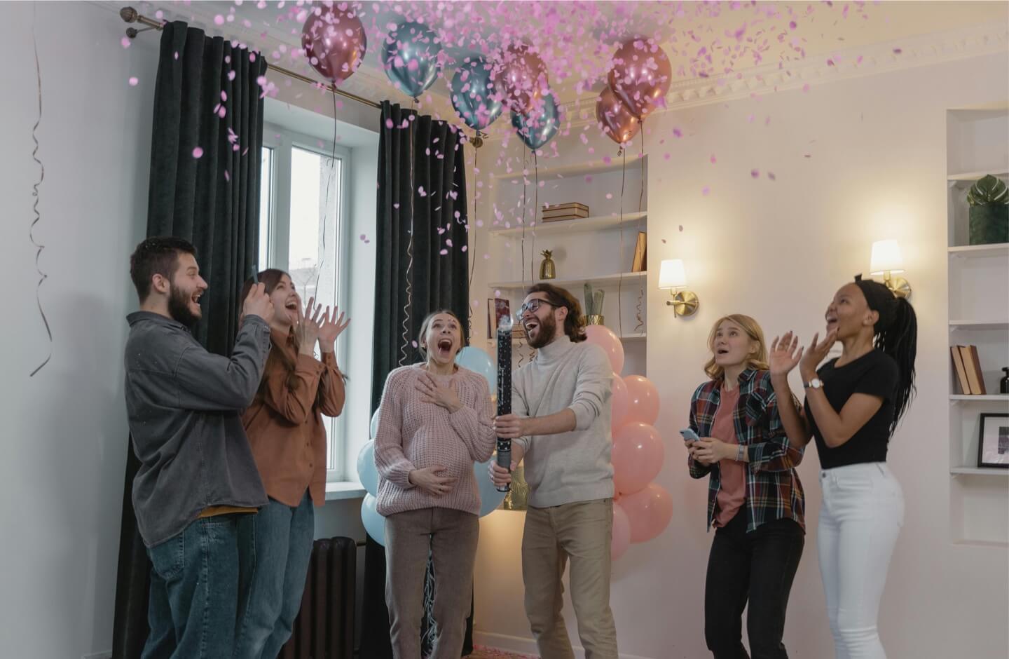 Celibrating gender reveal with multi-color balloons and confetti.